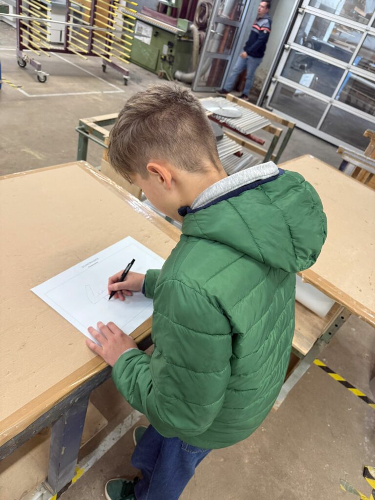 Ein Schüler des Werkschulheim Felbertal entwirft ein Klassenschild in der Tischlerei Schmidhuber in Seekirchen