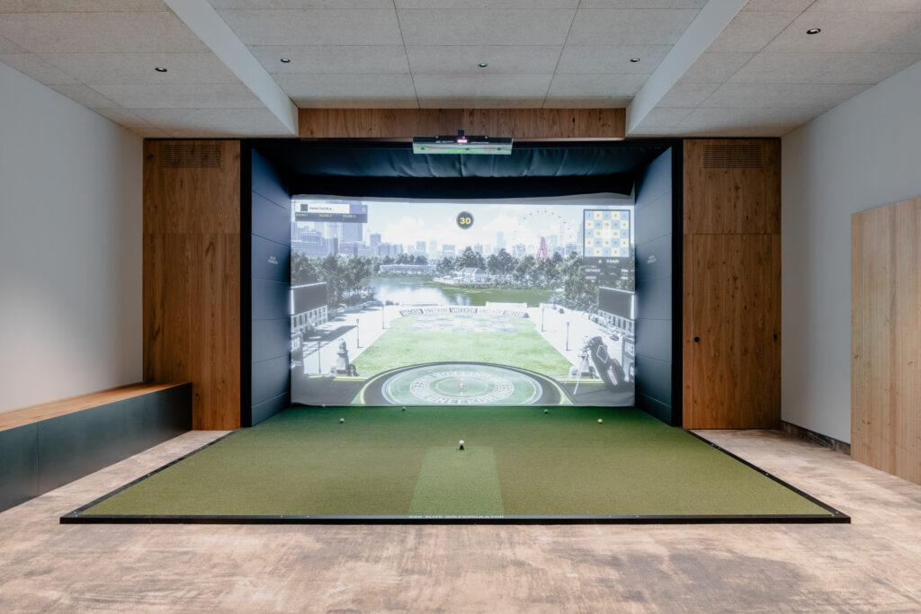 Golfsimulator mit Leinwand und Spielfläche in einem Hotel