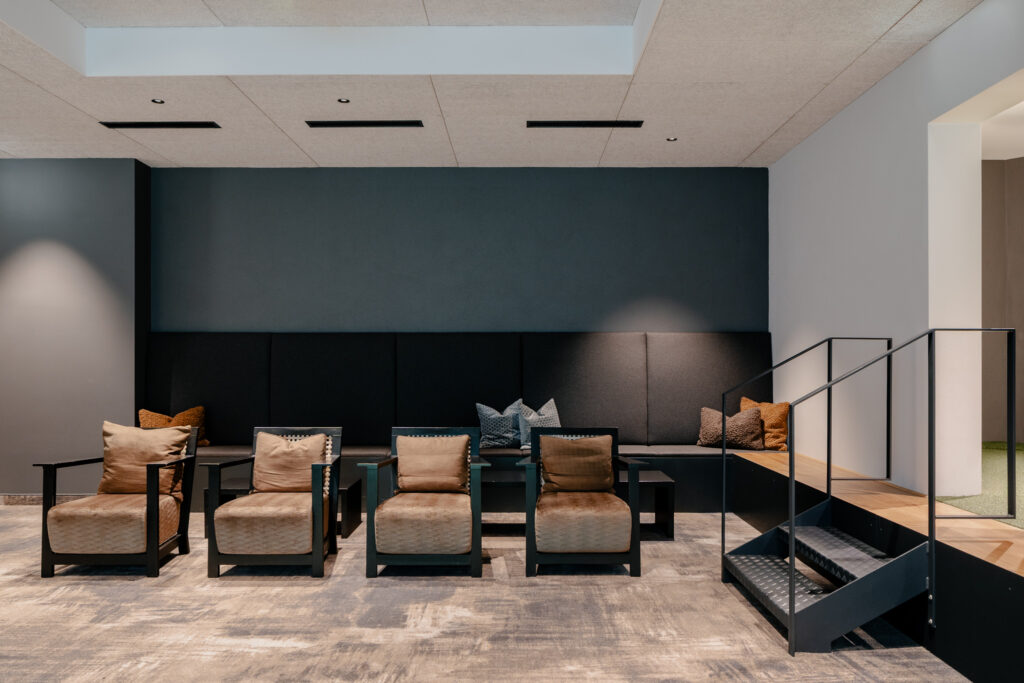 Sitzmöglichkeit mit Lounge Stühlen und gemütlicher Bank an der Wand in einem Hotel in Salzburg